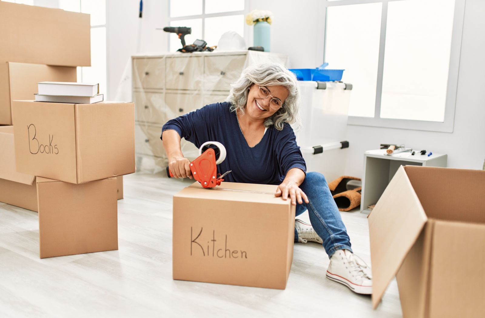 A senior woman packing up her belongings as she downsizes and moves to a senior living community.