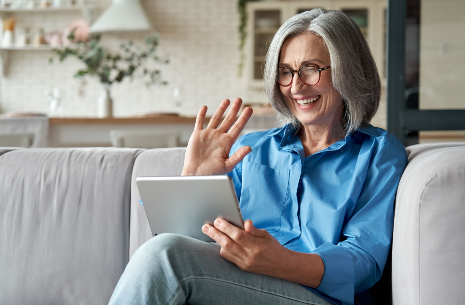 A senior resident video calls a family member via a tablet.